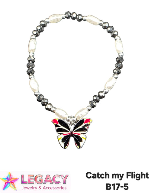 A beaded necklace with alternating white baroque pearls and faceted dark gray beads, featuring a central butterfly charm with black, red, and yellow enamel detailing. The necklace is displayed on a white background with a 'Legacy Jewelry & Accessories' logo and the text 'Catch my Flight B17-5' at the bottom.
